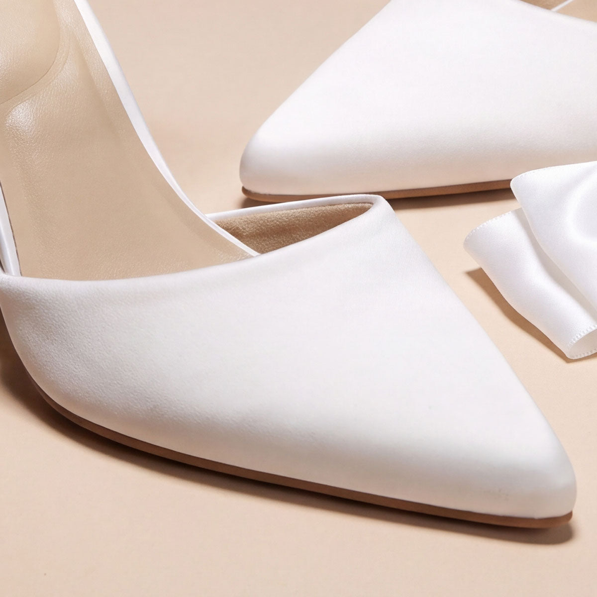 Close-up of the smooth satin upper and pointed toes on white pumps