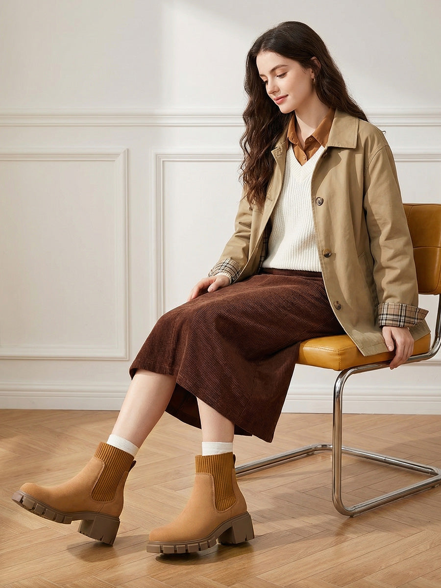 Tan Chelsea boots paired with white socks and a brown midi skirt