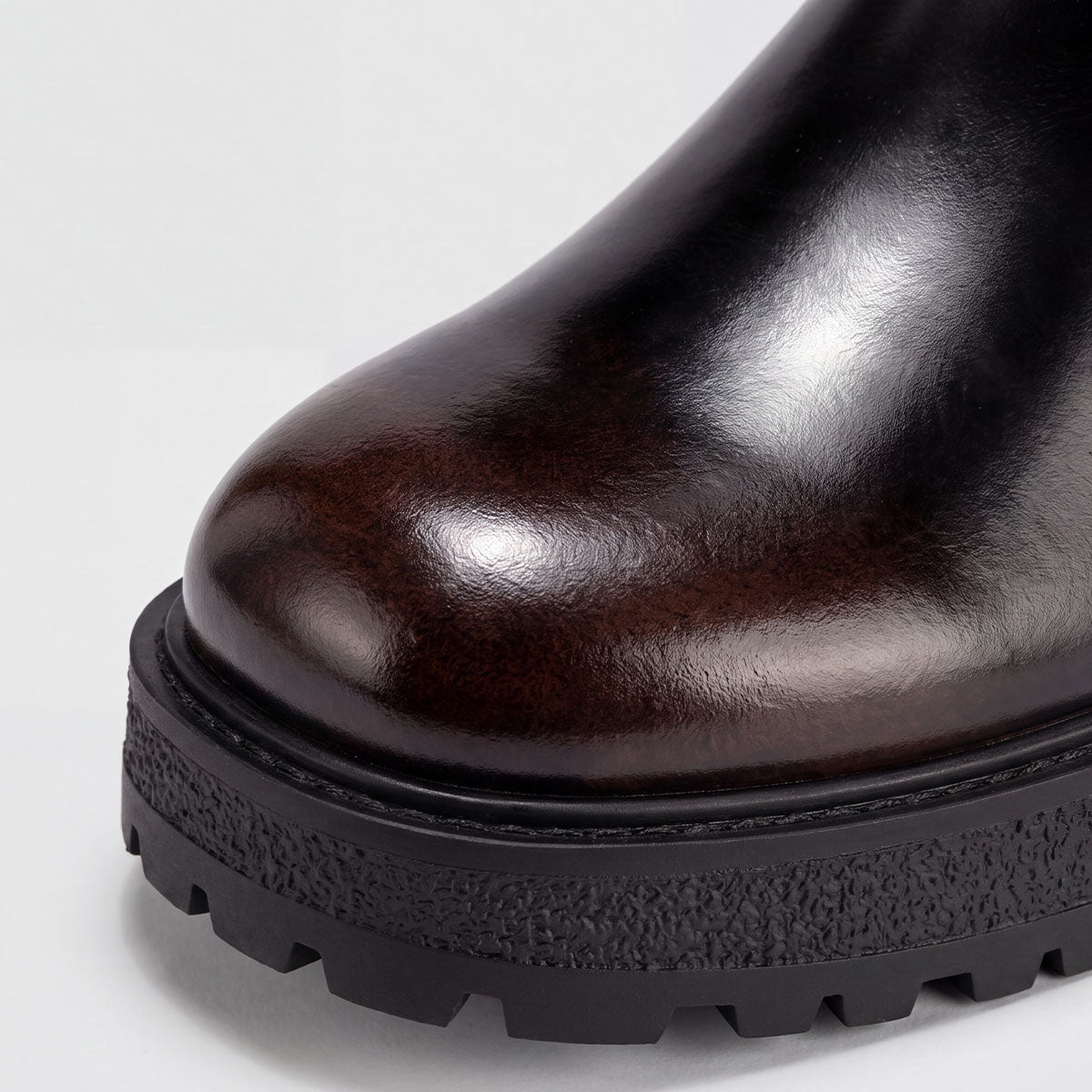 Close-up of the rounded toe and chunky lug sole on a black Chelsea boot