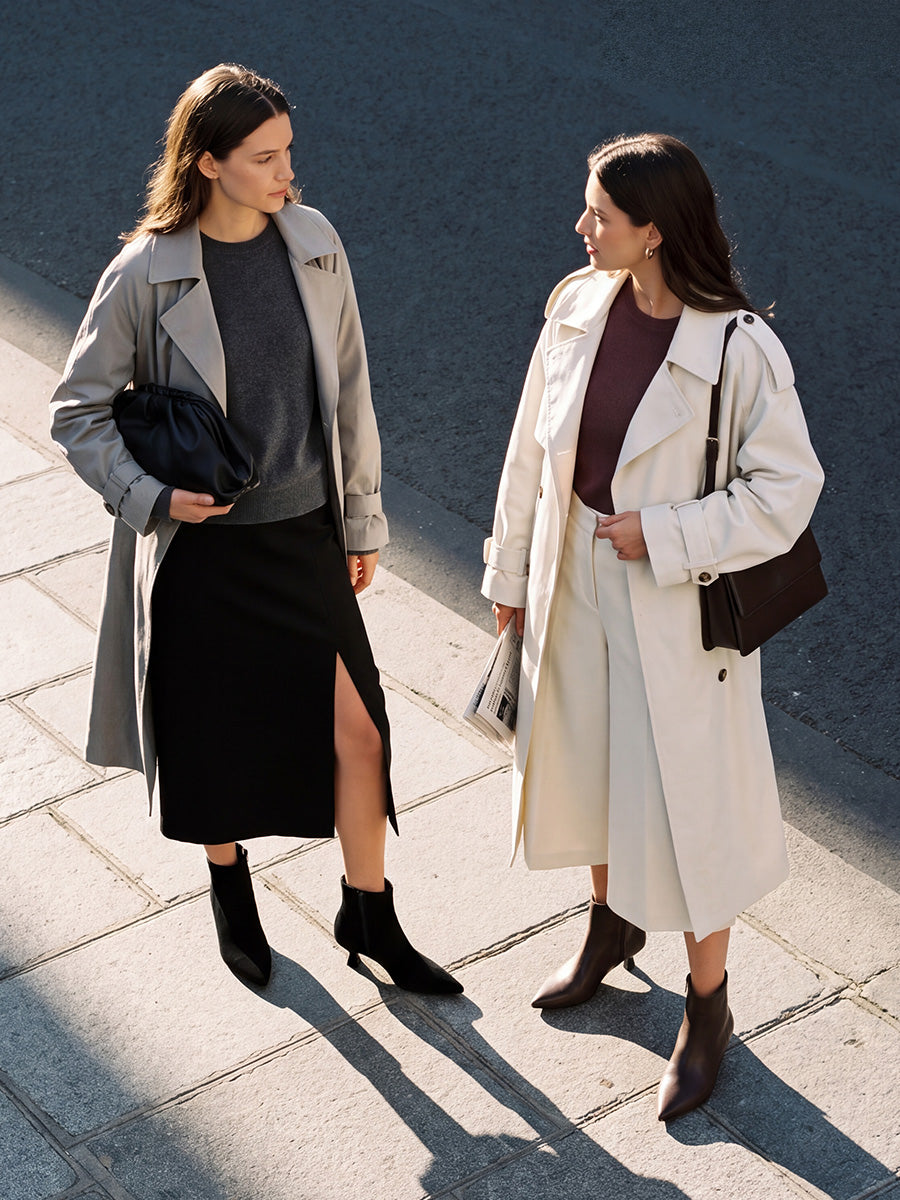 Two women crossing a street in black and chocolate kitten-heel ankle boots, styled with midi skirts and light jackets