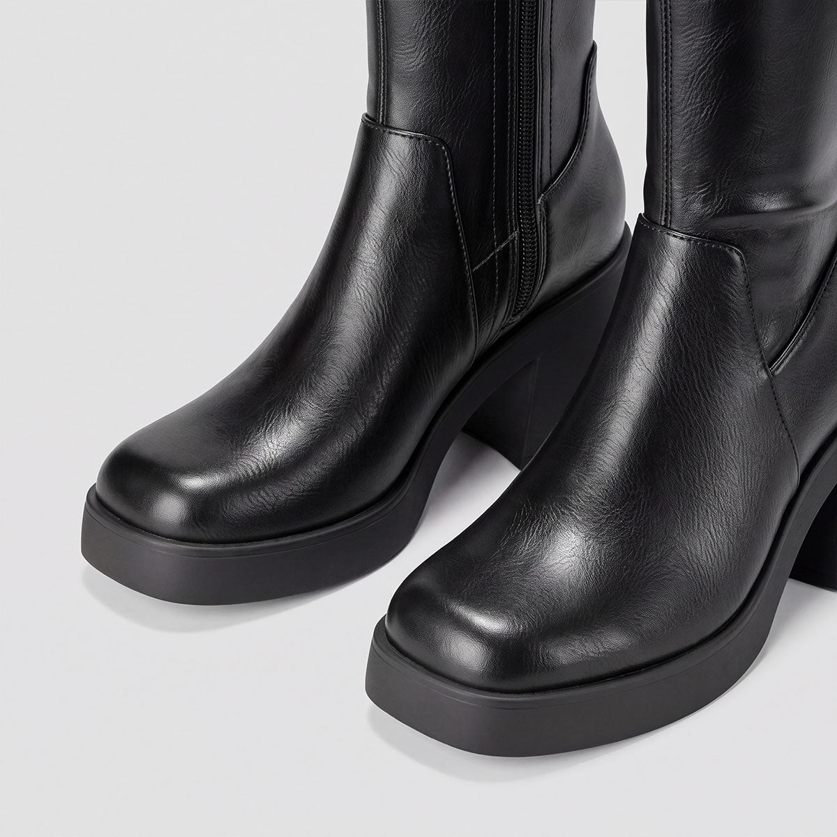 Close-up of the rounded toes and raised platform soles on black knee-high boots
