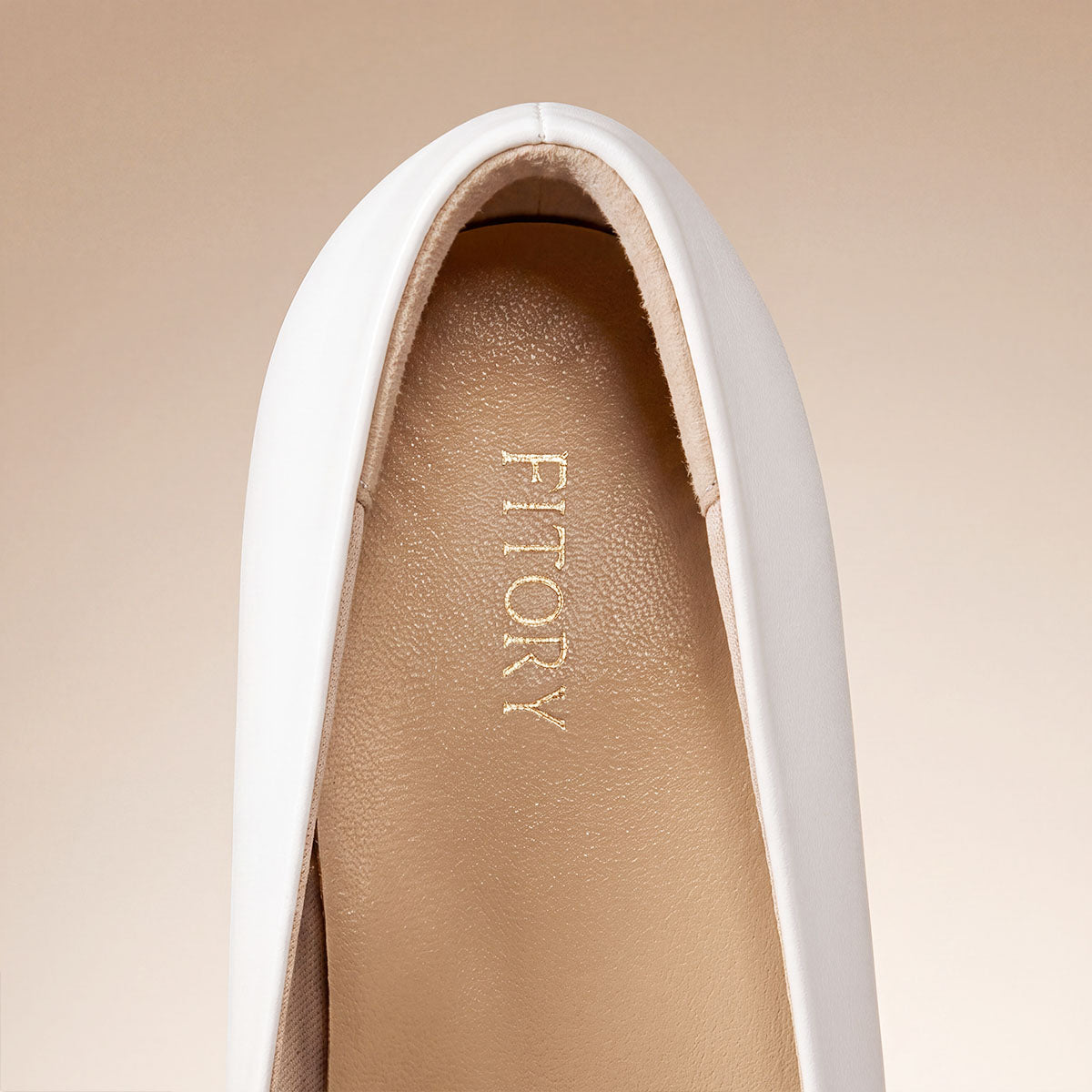 Close-up of the padded heel cushion inside a white pointed-toe pump