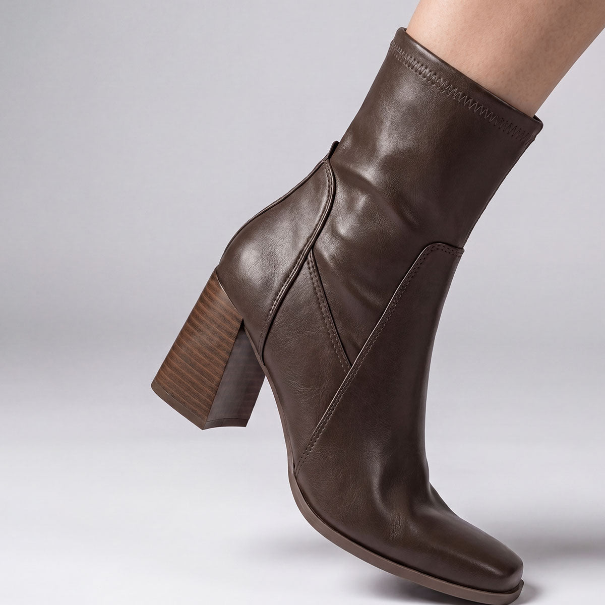 Side view of a chocolate square-toe ankle boot showing the stretch shaft fitted around the ankle