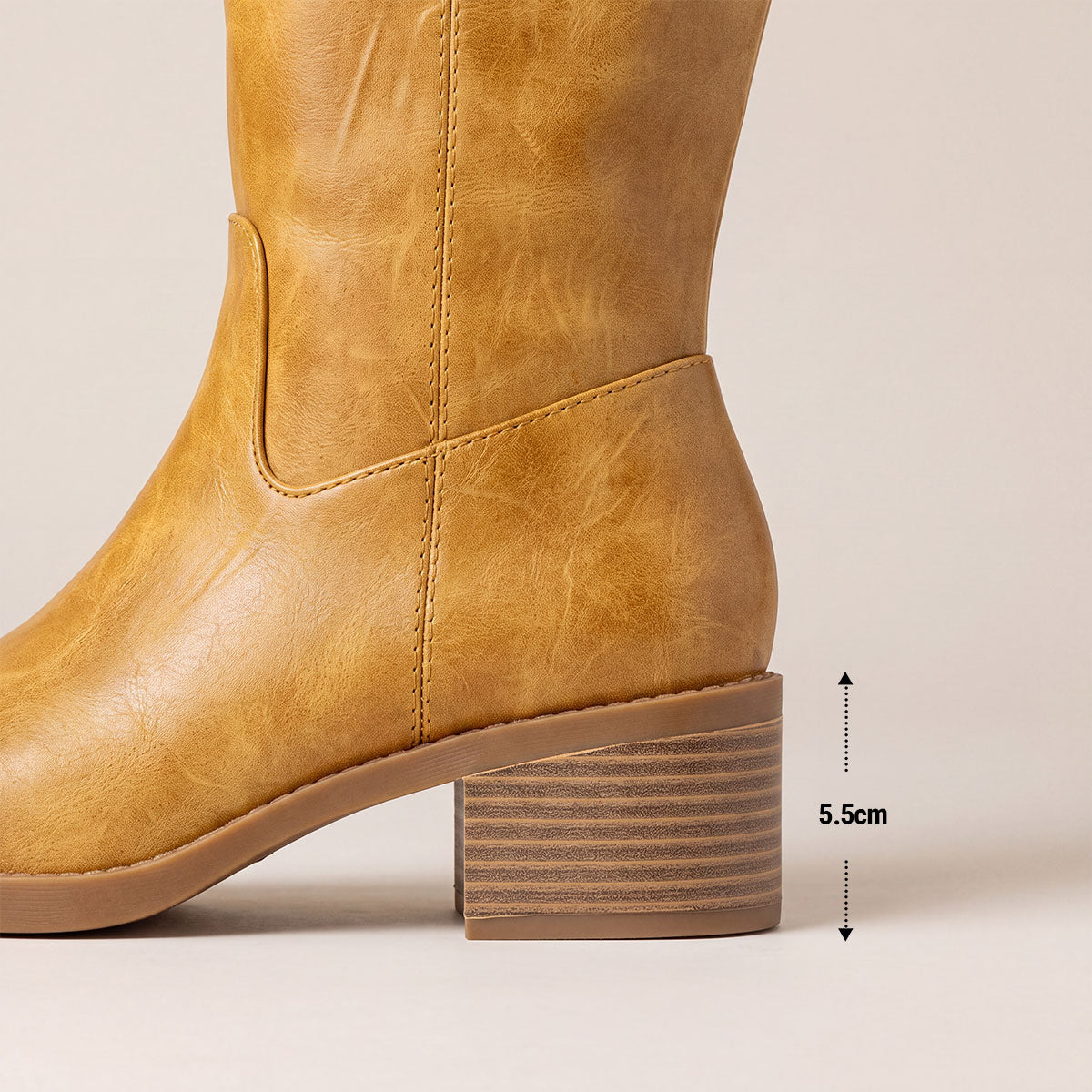 Side view of the striped block heel on a yellow knee-high boot, with a heel height marked as 5.5 cm